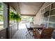 Relaxing covered porch featuring wood-look flooring, a dining set, and hanging plants at 2909 Huntsville Rd, Pendleton, IN 46064