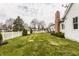 Expansive backyard featuring a lush lawn, a white picket fence, and mature trees creating a serene outdoor space at 311 2Nd Ne St, Carmel, IN 46032