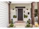 Welcoming front entrance with dark door, stylish lanterns, and well-manicured landscaping at 311 2Nd Ne St, Carmel, IN 46032