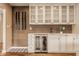 Stylish wet bar features custom cabinetry, wine cooler, and tiled backsplash at 311 2Nd Ne St, Carmel, IN 46032