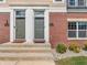 Close-up of townhouse entrances with brick and light-colored siding at 317 Alden Way, Carmel, IN 46032