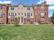 Charming townhome featuring a brick facade, green lawn, and inviting entrances at 317 Alden Way, Carmel, IN 46032