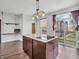 Kitchen featuring an island with cooktop and granite countertops with views of the deck and entryway at 317 Alden Way, Carmel, IN 46032