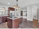 Spacious kitchen and dining area featuring an island cooktop, stainless refrigerator, and breakfast bar at 317 Alden Way, Carmel, IN 46032