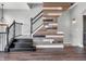 Elegant staircase with modern wood accent wall and laminate flooring at 317 Alden Way, Carmel, IN 46032