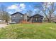Back exterior view of a home with a stone chimney, wooden deck, and a screened-in porch at 3244 Devereaux Dr, Indianapolis, IN 46228