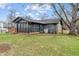 Exterior of a home with a screened-in porch, stone accents, and mature trees at 3244 Devereaux Dr, Indianapolis, IN 46228