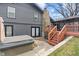 Exterior view of the backyard featuring a deck with stairs, stone chimney, and hot tub at 3244 Devereaux Dr, Indianapolis, IN 46228