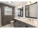 Modern bathroom features gray cabinets with double sinks, modern fixtures, and a well lit window at 3244 Devereaux Dr, Indianapolis, IN 46228