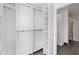 Spacious walk-in closet with custom shelves and marble tile leading to a connected bathroom at 3244 Devereaux Dr, Indianapolis, IN 46228
