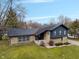 Aerial view of charming two-story home with unique stone and wood siding, a well-manicured lawn, concrete walkway at 3244 Devereaux Dr, Indianapolis, IN 46228