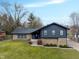 Charming two-story home with unique stone and wood siding, a well-manicured lawn, and a concrete walkway leading to the front door at 3244 Devereaux Dr, Indianapolis, IN 46228