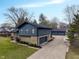 Aerial view of home showing attached garage and detached garage, expansive driveway, lawn, wood and stone siding at 3244 Devereaux Dr, Indianapolis, IN 46228