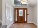 Foyer with wood-look floors, a front door with leaded glass, coat closet and unique transom window at 3244 Devereaux Dr, Indianapolis, IN 46228