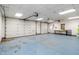 Interior shot of an empty two-car garage with white walls and a blue floor at 3244 Devereaux Dr, Indianapolis, IN 46228