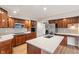 Stylish kitchen featuring wood cabinets, stainless steel appliances, subway tile backsplash, and a central island with stone countertop at 3244 Devereaux Dr, Indianapolis, IN 46228