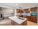 Open kitchen with stainless appliances, custom wood cabinets and large island with quartz countertop at 3244 Devereaux Dr, Indianapolis, IN 46228