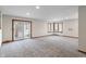 Large living room with neutral color scheme, plush carpeting, and sliding glass doors at 3244 Devereaux Dr, Indianapolis, IN 46228
