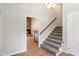 Carpeted staircase with wooden handrail, leading to the upper level, located off the home's entry foyer at 3244 Devereaux Dr, Indianapolis, IN 46228