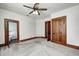 This carpeted bedroom has a ceiling fan, natural wood trim and multiple doors at 331 W State St, Pendleton, IN 46064