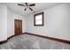 Bedroom features neutral carpet, white walls with wood trim, wood paneled door, and a window at 331 W State St, Pendleton, IN 46064