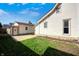 View of backyard with grass, concrete pad, and a white exterior with black framed windows at 331 W State St, Pendleton, IN 46064