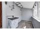 Cozy laundry room featuring gray walls, wood look flooring, and a utility sink with cabinet at 331 W State St, Pendleton, IN 46064