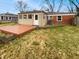 Large backyard featuring a wooden deck, well-kept lawn, and a brick home at 3662 Lombardy Pl, Indianapolis, IN 46226