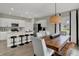 Stylish dining space showcasing a wooden table, modern lighting, bar stools, and an open kitchen view at 3740 Sunset Ridge Dr, Franklin, IN 46131