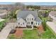 Stunning aerial view of a two-story home with gray roof, landscaped yard, and mature trees at 3892 Pelham Rd, Carmel, IN 46074