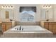 Luxury bathroom featuring a large garden tub centered between dual sinks, a picture window, and tile flooring at 3892 Pelham Rd, Carmel, IN 46074