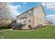 A view of the home's exterior, with a deck, patio, brick facade, and lush green lawn at 3892 Pelham Rd, Carmel, IN 46074