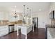Well-lit kitchen featuring stainless appliances, a granite island, and hardwood floors at 3892 Pelham Rd, Carmel, IN 46074