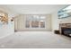Spacious living room with large windows, stone fireplace, and neutral carpet at 3892 Pelham Rd, Carmel, IN 46074