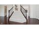 Elegant staircase with carpeted steps, dark wood railing, and open floor plan at 3892 Pelham Rd, Carmel, IN 46074