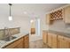 Basement wet bar area features granite countertop, tile backsplash, light wood cabinets, and stainless-steel sink at 3892 Pelham Rd, Carmel, IN 46074