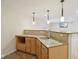 Close up view of wet bar in basement featuring granite countertops, tile backsplash, and light wood cabinets at 3892 Pelham Rd, Carmel, IN 46074