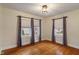 Bright bedroom with hardwood floors, two windows, and stylish curtains offers a welcoming space at 3901 S Meridian St, Indianapolis, IN 46217
