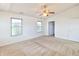 Bright bedroom with neutral carpet, ceiling fan, two windows, and an open closet door at 4043 Oak Trail Dr, Indianapolis, IN 46237