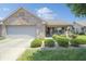 Charming brick home with a manicured front yard and attached garage on a sunny day at 4043 Oak Trail Dr, Indianapolis, IN 46237