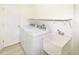 Well-lit laundry room with modern washer, dryer, sink, and ample shelving at 4043 Oak Trail Dr, Indianapolis, IN 46237