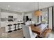 Modern dining area with a large wooden table, bar stools, and an open view to the kitchen at 4523 Laughter Ln, Indianapolis, IN 46235