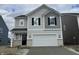 Charming two-story home with a two-car garage, black shutters and light gray vinyl siding at 4523 Laughter Ln, Indianapolis, IN 46235