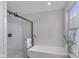Stylish bathroom featuring a modern tub and glass enclosed shower with white tiled walls at 4801 Copper Grove Dr, Indianapolis, IN 46237