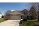 Charming two-story brick home featuring an attached two-car garage and a well-manicured lawn at 4801 Copper Grove Dr, Indianapolis, IN 46237