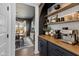Charming Butler's Pantry features dark cabinetry, butcher block countertop, and floating shelves at 5387 Citadel Dr, Noblesville, IN 46062