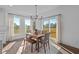 Bright dining area with a wooden table, bench seating, and natural light from the sliding glass doors at 5387 Citadel Dr, Noblesville, IN 46062