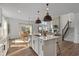 Open-concept kitchen features an island, stainless steel appliances, and flows into a living room with a fireplace at 5387 Citadel Dr, Noblesville, IN 46062