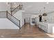 Open-concept space showcasing a staircase and a modern kitchen with stainless steel appliances and an island at 5387 Citadel Dr, Noblesville, IN 46062
