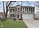 Two-story home featuring brick and vinyl siding, a two-car garage, and green shutters at 5869 Jamestown Square Ln, Indianapolis, IN 46234
